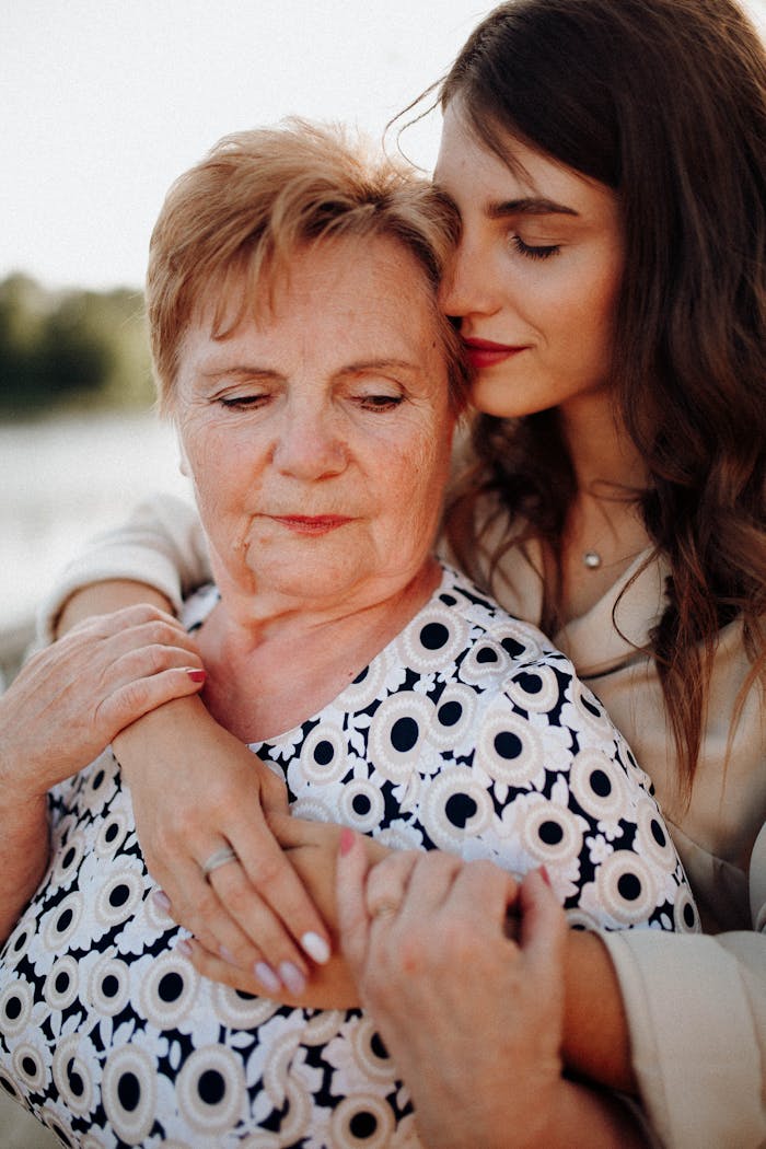 why-choose-us Elderly mother and young daughter embracing in a warm, loving moment.
