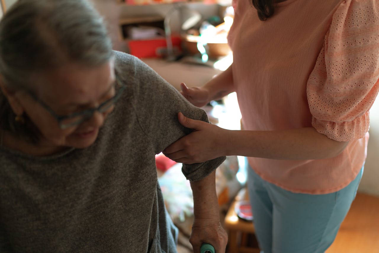 hero-img-02 Compassionate caregiver helps elderly woman with mobility at home, offering caring support.